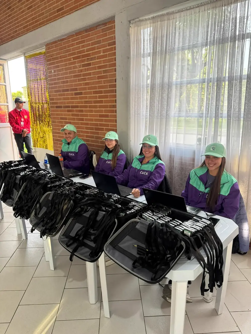 Equipo de registro de CLICK con uniforme, junto a la mesa con los controles de votación