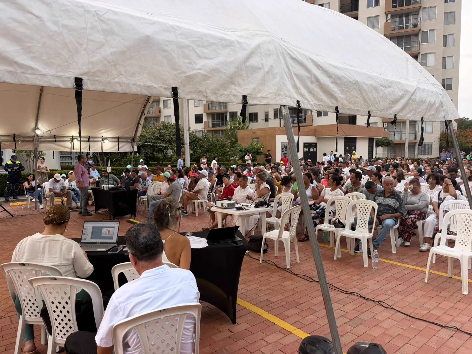 Asamblea bajo carpa con mesa de control y sonido. CLICK, logística y votación electrónica para asambleas.