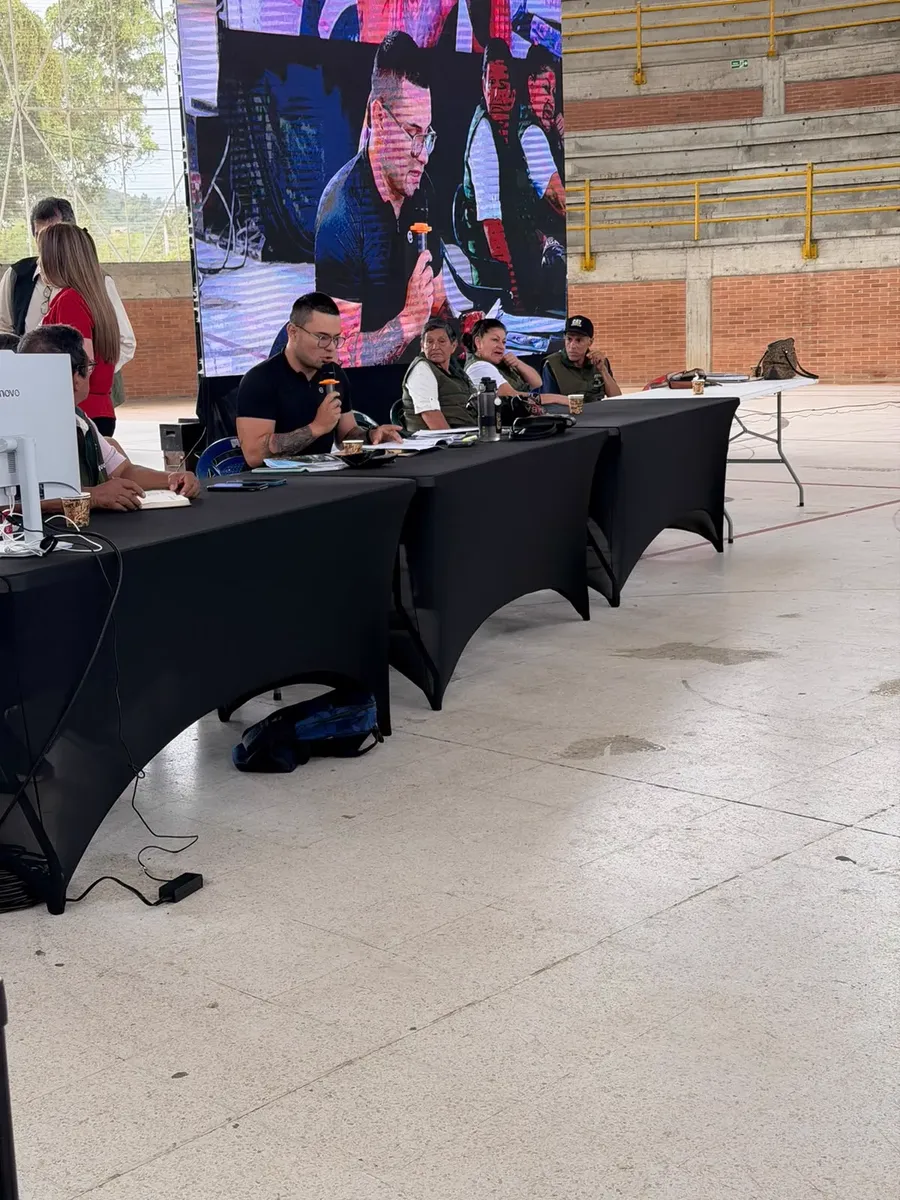 Asamblea en un coliseo con montaje de CLICK: la cámara toma a quien habla en la mesa directiva y la pantalla LED lo muestra en vivo